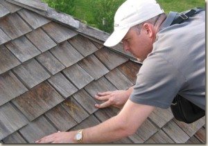 A Man wearing a cap fixing the roofing of a house